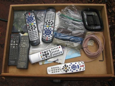 The auxiliary remotes drawer, including the two black and silver remotes for my Dish receiver.